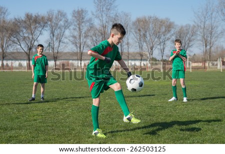 Boys kicking football on the sports field