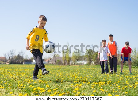 Boys kicking football on the  field