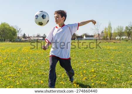 Boys kicking football on the  field