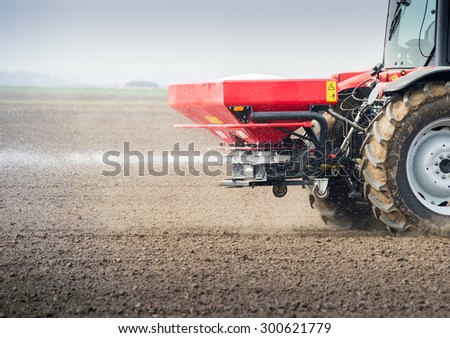 Tractor and fertilizer spreader in field