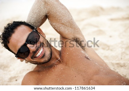 Portrait of an attractive young model lying on a tropical beach
