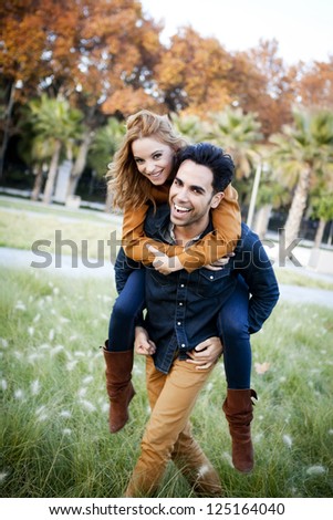 Young couple in the countryside. Piggyback ride.