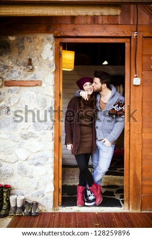 Young cheerful couple in a cabin in romantic scape in winter