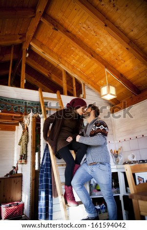Young couple kissing in a cabin in romantic scape in winter