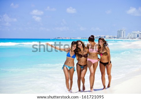 Group of friends having fun, walking at the paradise beach of Cancun