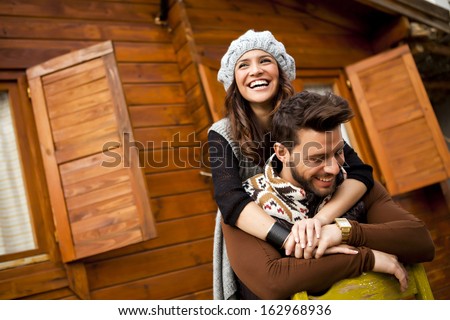 Young Cheerful Couple In A Cabin In Romantic Scape In Winter