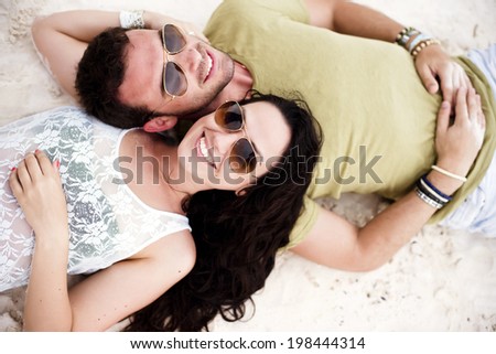 Above shot of a young couple in love in a tropical beach. Shot from above.