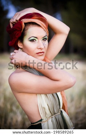 Soft colored portrait of a fashion model with a tribal style. Shoot at dusk for a melancholic effect.
