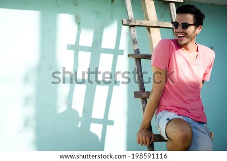 Portrait of a young handsome man, fashion model, with toupee in urban background