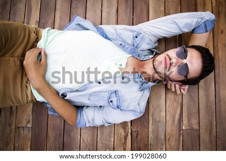 Young man lying on a wooden floor