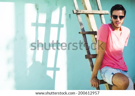 Portrait of a young handsome man, fashion model,  in urban background