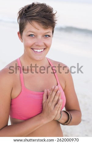 Woman praying with hands on her heart, staring at the camera