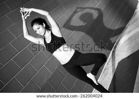 Woman practicing yoga against a brick wall