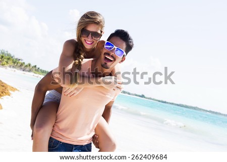 Young couple piggybacking at the beach