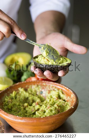 Chef serving guacamole with a spoon