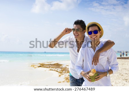 Gay couple drinking a coconut in the Caribbean