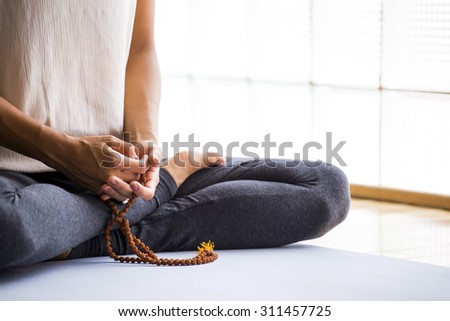 Young latin woman practicing meditation indoors.