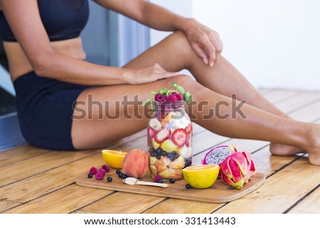 Unrecognizable sportive woman with a healthy breakfast in a mason jar
