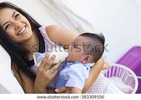 Beautiful mexican woman feeds her baby