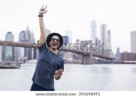 Man listening music with a rock sign hand up in Brooklyn, New York