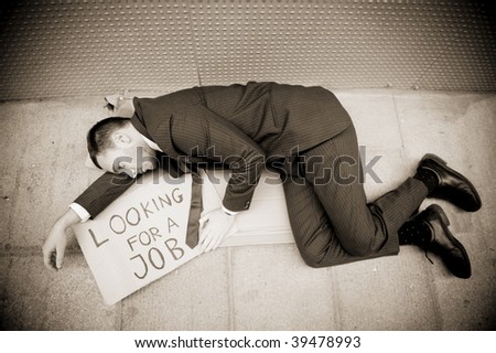 Young businessman laying over a sign Looking for a job