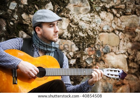 Young spanish man playing classic guitar