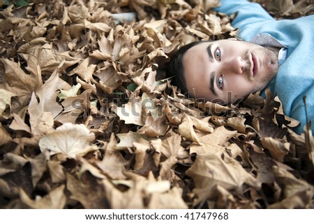 Young handsome man staring at camera in autumn background