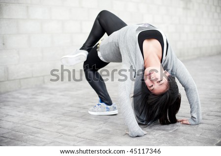 Asian girl doing bridge pose in gym clothes.
