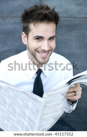 Young handsome man reading newspaper