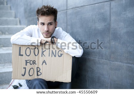 Young businessman holding sign Looking for a job