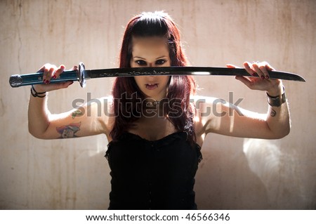 Beautiful woman posing with katana sword.