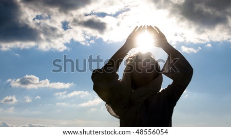 Young woman doing meditation with sun in her hands.
