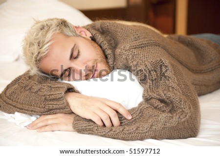 Young handsome man sleeping in bed