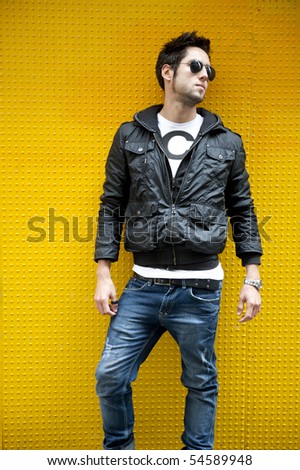 Young attractive man against yellow wall