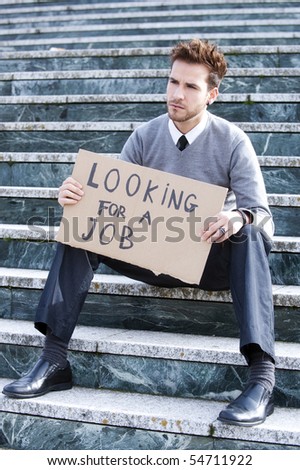 Young businessman holding sign Looking for a job