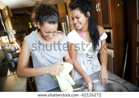 Two young friends wash the dishes