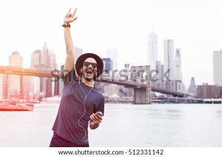 Man listening music with a rock sign hand up in Brooklyn, New York