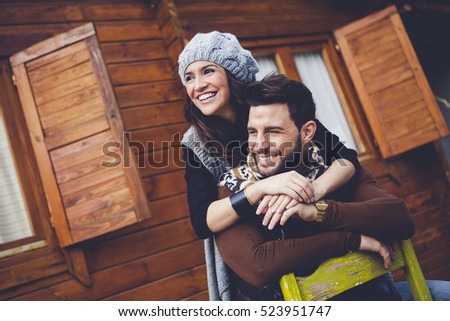 Young cheerful couple in a cabin in romantic scape in winter