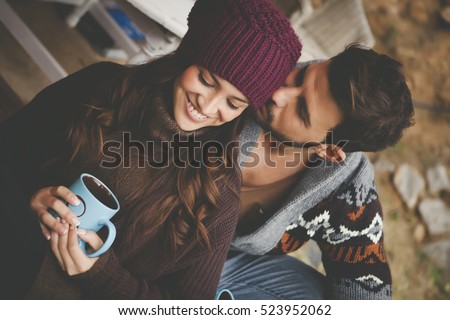 Young couple having breakfast in a romantic cabin outdoors in winter.