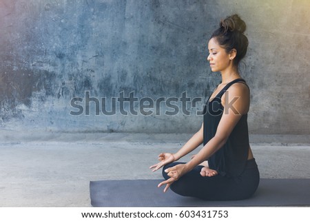 Woman practicing meditation in a urban background