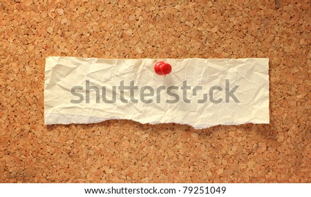 long paper on corkboard attached with thumbtack. ready for your text