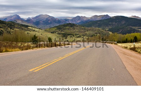 curving road pointing towards mountain peaks in the Pikes Peak region of Colorado, USA, Pikes Peak shrouded in the clouds