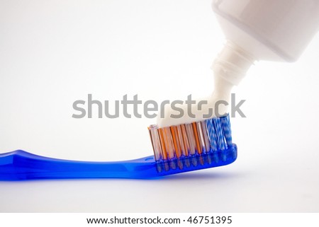 Putting tooth paste on blue brush isolated on a white background.