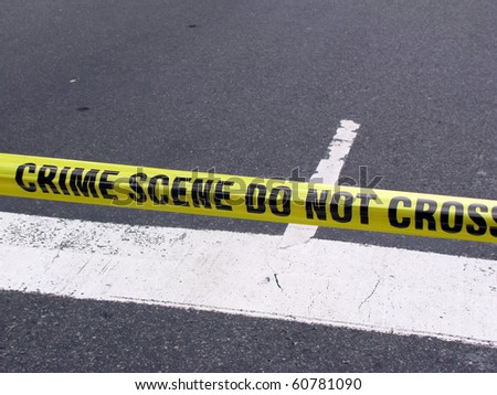 Street crime scene with police line do not cross yellow warning tape above road