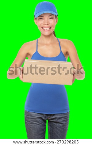 Female package delivery person giving packages wearing blue uniform. Woman courier smiling happy isolated on green screen chroma key background. Young mixed race Caucasian Chinese Asian female courier