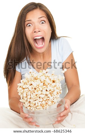 Woman scared funny watching scary movie. Beautiful girl watching movie in bed on white background