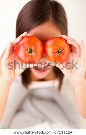 Tomato. Woman showing tomatoes. Cute funny image of girl holding tomatoes in front of her eyes.