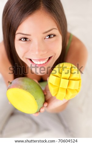 Mango fruit. Woman showing a mango fruits, cut and sliced.