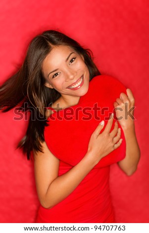 love woman showing red heart. Love concept photo with young woman in love holding red heart on red background. Multiracial asian caucasian valentines day woman.