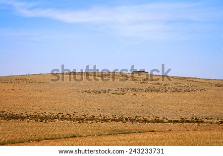 Desert landscape with tent on horizon line